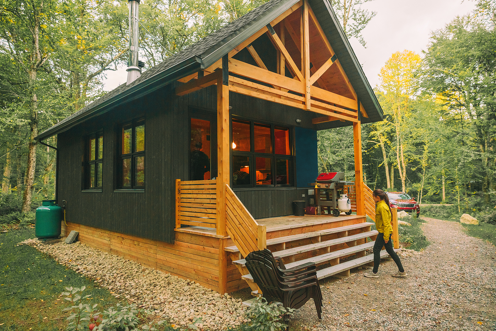 Vacation rental forest lodge countryside cabin by the lake for holidays in the wilderness. Woman entering her house home away from home.